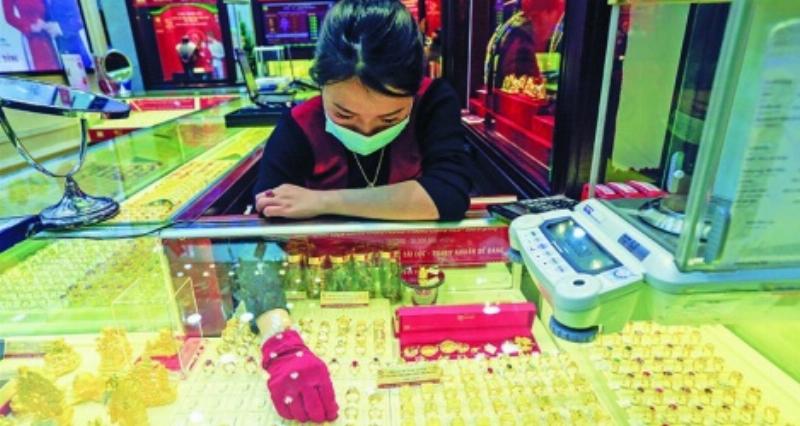 Nhân viên đang kiểm tra hoặc cân vàng tại quầy giao dịch của Bảo Tín Minh Châu, thể hiện sự minh bạch và chuyên nghiệp trong giao dịch